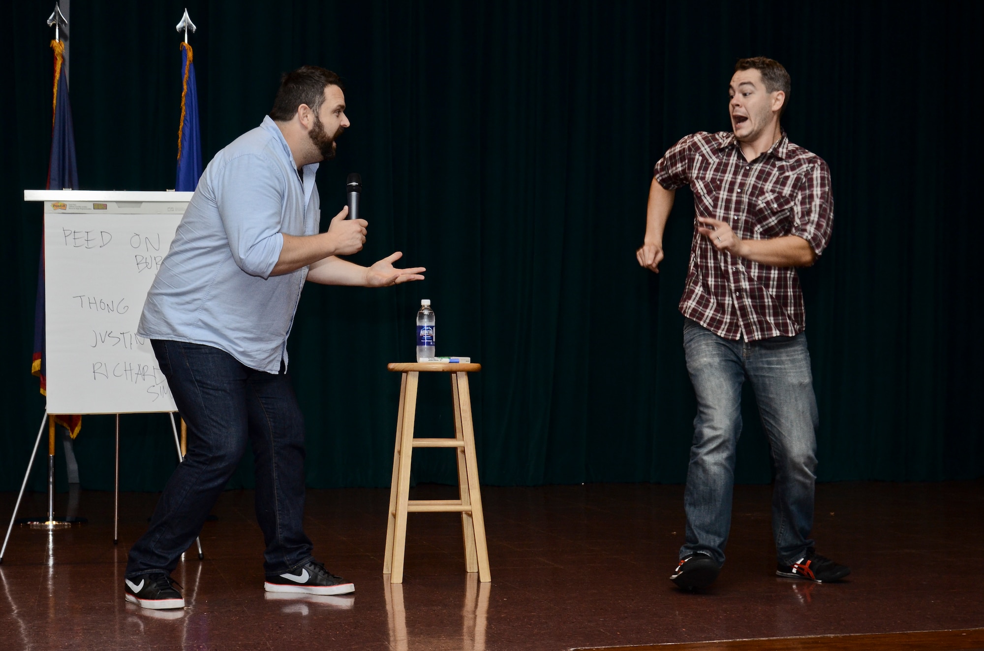 Bryce Wissel (right), acts out a scene from a drunk party to Colin Sweeney (left), both "A Shot of Reality With a Comedy Chaser" cast members, July 31, 2014, on Andersen Air Force Base, Guam.  Joint Region Marianas sponsored the comedy show designed to educate Airmen and Sailors on the dangers and responsibilities that come with drinking alcohol. (U.S. Air Force photo by Staff Sgt. Robert Hicks/Released)