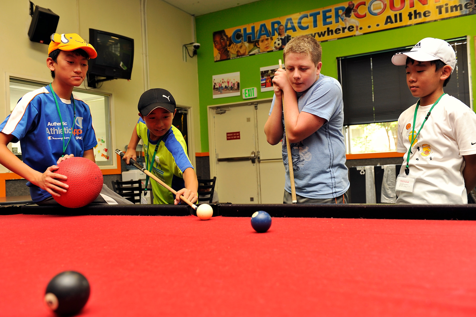 Japanese primary school children from Achi Village, Nagano, play pool at the youth center during a visit on Kadena Air Base, Japan, Aug. 4, 2014. Japanese children interacted with American children their own ages and spent time playing video games, dodgeball and pool with the military children in an effort to learn more about life on a military base. (U.S. Air Force photo by Naoto Anazawa/Released)