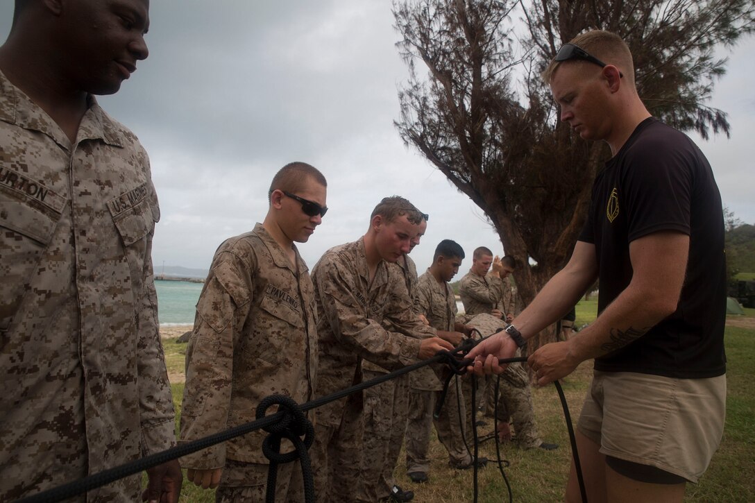 Staff Sgt. Kristopher L. Privitar, right, examines Marines’ knots following a timed knot tying drill as part of a month-long coxswains course July 22 at White Beach Naval Facility, Okinawa, Japan. Throughout the course the Marines learn how to operate a Combat Rubber Raiding Craft, read nautical charts, and tie knots used in small boat operations. Following completion of the course the Marines will gain an additional military occupational specialty of 0316, or CRRC coxswain. Privitar is an amphibious raids instructor with Special Operations Training Group, III Marine Expeditionary Force Headquarters Group, III MEF. The Marines are with various units assigned to 3rd Marine Division, III MEF.