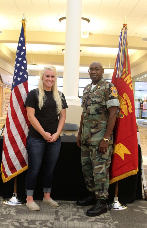 U.S. Marine Corps Lance Cpl. Kristin Toler, a field radio operator with the Fire Support Coordination Center, 10th Marine Regiment, 2nd Marine Division, poses for a photo with retired Sgt. Maj. Ernest Flowers III, the commanding officer of the New Bern Young Marines, during a Young Marine meeting at the New Bern Mall in New Bern, N.C., July 18, 2014. Toler spent most of her life as a Young Marine before joining the Marine Corps in 2013. Now she gives back to the organization by volunteering once a week. (Official U.S. Marine Corps photo by Sgt. Dwight A. Henderson/Released)