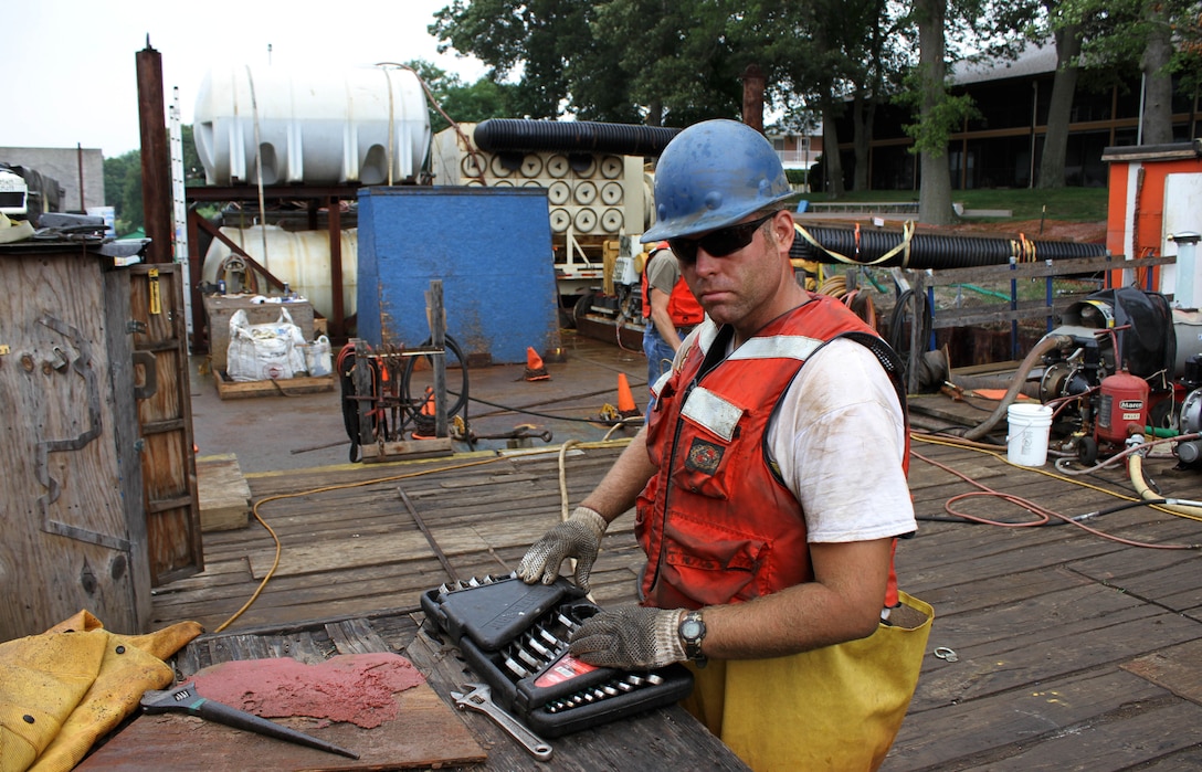 Jason Bolks, a foreman for Abhe & Svoboda Inc., checks on equipment during operations on the Point Pleasant Canal in New Jersey in August of 2014. The U.S. Army Corps of Engineers' Philadelphia District and its contractor Abhe & Svoboda are repairing and coating a section of the canal bulkhead as part of Hurricane Sandy recovery work. (Photo by Tim Boyle)