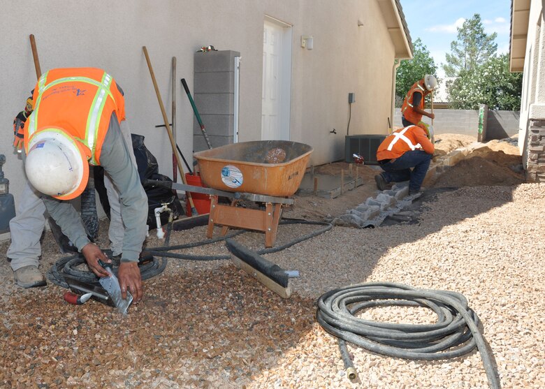 Workers with American Integrated Services, Inc., a subcontractor for the U.S. Army Corps of Engineers Los Angeles District’s Time Critical Removal Action of a Formerly Used Defense Site just outside Kingman, rebuild a wall between two properties July 29 which was taken down during the “construction phase” of the cleanup project. The “construction phase” of the removal included providing temporary relocation assistance for residents and their pets while cleanup was being done from nearly 60 properties; removing the landscaping, rocks and other similarly mobile items on each affected property and storing them in a secure location while the team removes soil on the property up to a depth of two feet; and restoring removed items to their original location unless the property owners or residents asked for the items to remain off of the property.