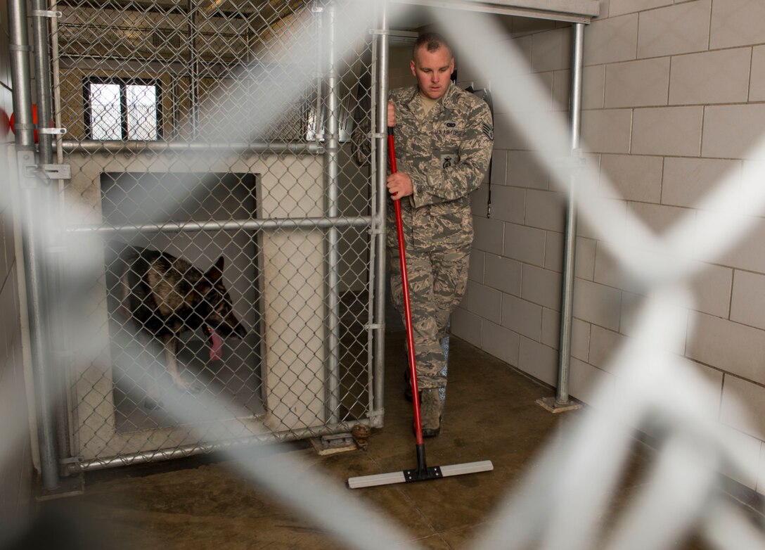 Staff Sgt. Tim Glover cleans the kennel of his Military Working Dog Roko July 28, 2014, on Minot Air Force Base, N.D. After watching MWD handlers work at his last base, Glover decided he wanted to specialize and applied to become one. Glover is a 5th Security Forces Squadron MWD handler. (U.S. Air Force photo/Senior Airman Stephanie Morris)