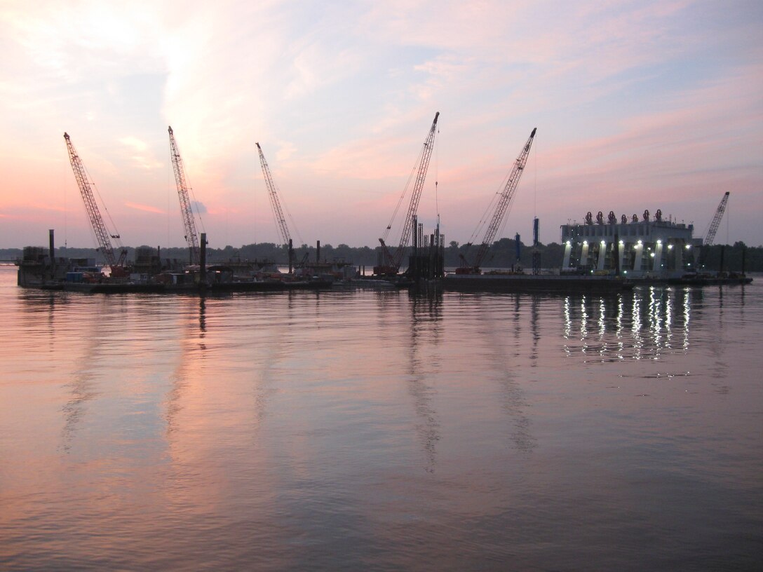 The Olmsted project delivery team members mark the start of another beautiful day by successfully setting Paving Block No. 4, the first element of the navigable pass portion of the Olmsted Dam on July 31.  Now begins the final planned construction sequence of the dam. In this final phase, 13 shells and the 11 additional paving blocks will be placed. This is a necessary procedure to complete the Olmsted Dam.  

The final two shells of the tainter gate portion of the dam were successfully set earlier this low water season.   
