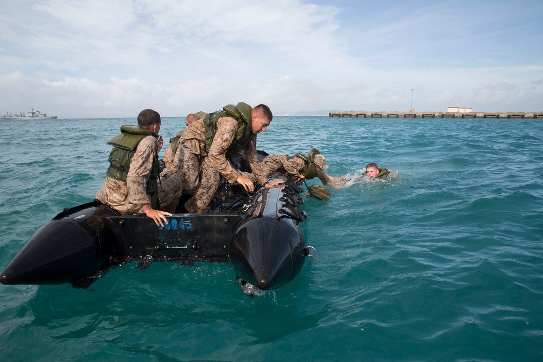 Marines stabilize their Combat Rubber Raiding Craft after broaching the craft during a month-long coxswains course July 22 at White Beach Naval Facility, Okinawa, Japan. The purpose of broaching is to simulate a small boat capsizing in turbulent waters and complete the steps necessary to recover the craft. Following completion of the course the Marines will gain an additional military occupational specialty of 0316, or CRRC coxswain. The Marines are with various units assigned to 3rd Marine Division, III Marine Expeditionary Force.