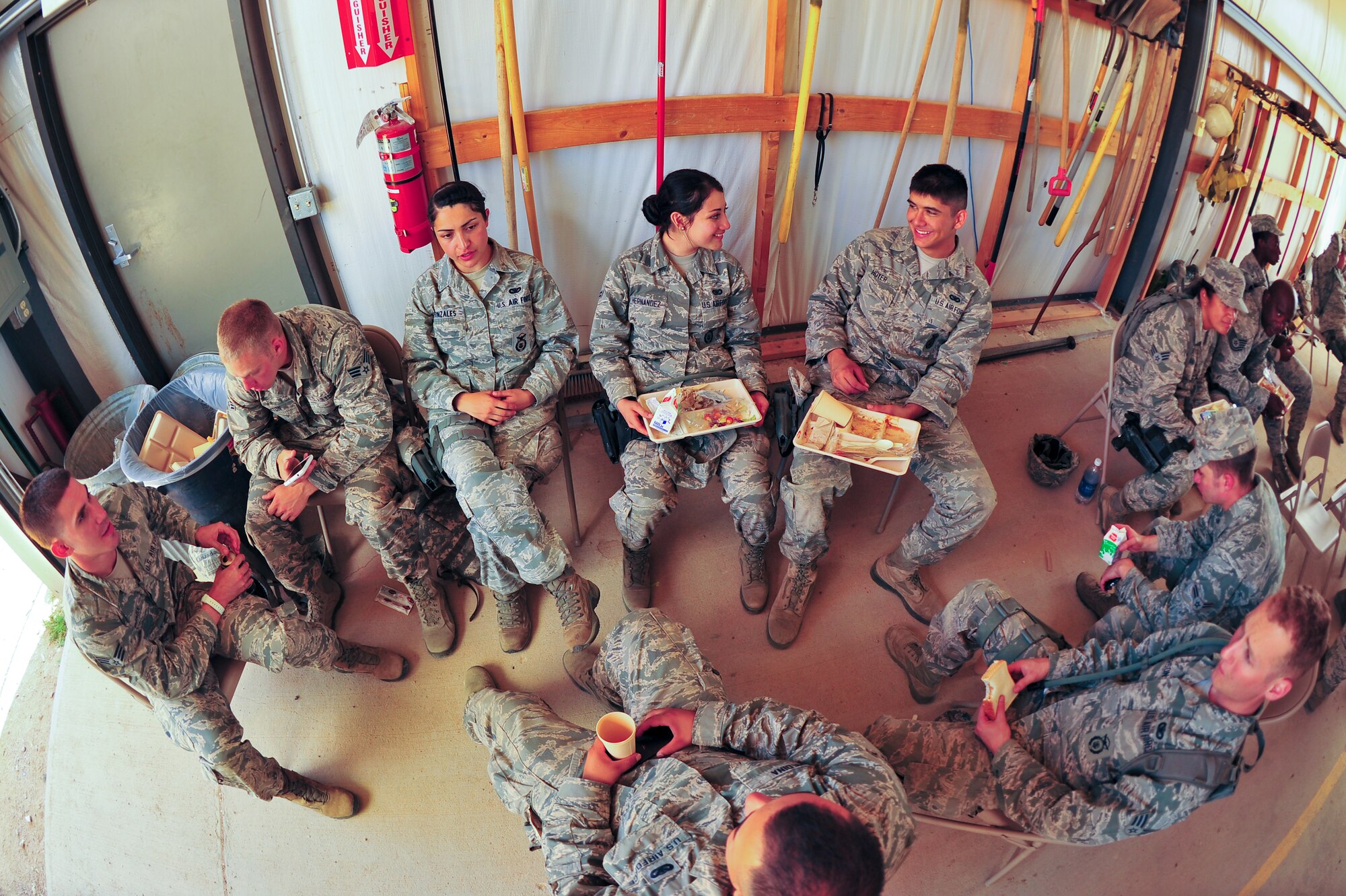 Air Force Reservists from the 310th and 710th Security Forces Squadrons take a break and have a meal after exercising in the field August 2, 2014, at Fort Carson’s Airburst range in Pueblo, Colo. Food support was given by the 310th Sustainment Services Flight.