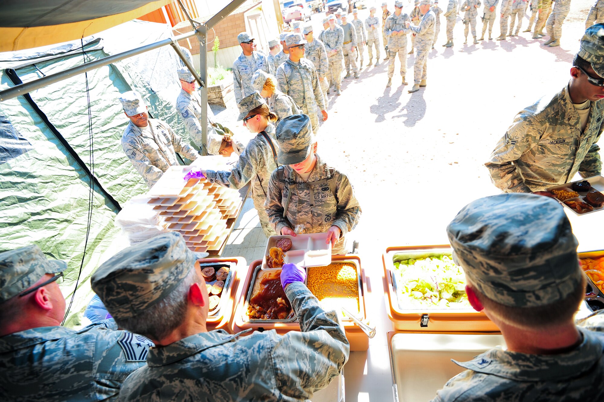 Air Force Reservists from the 310th and 710th Security Forces Squadrons receive dinner in a field environment August 2, 2014, at Fort Carson’s Airburst range in Pueblo, Colo. Food support was given by the 310th Sustainment Services Flight.