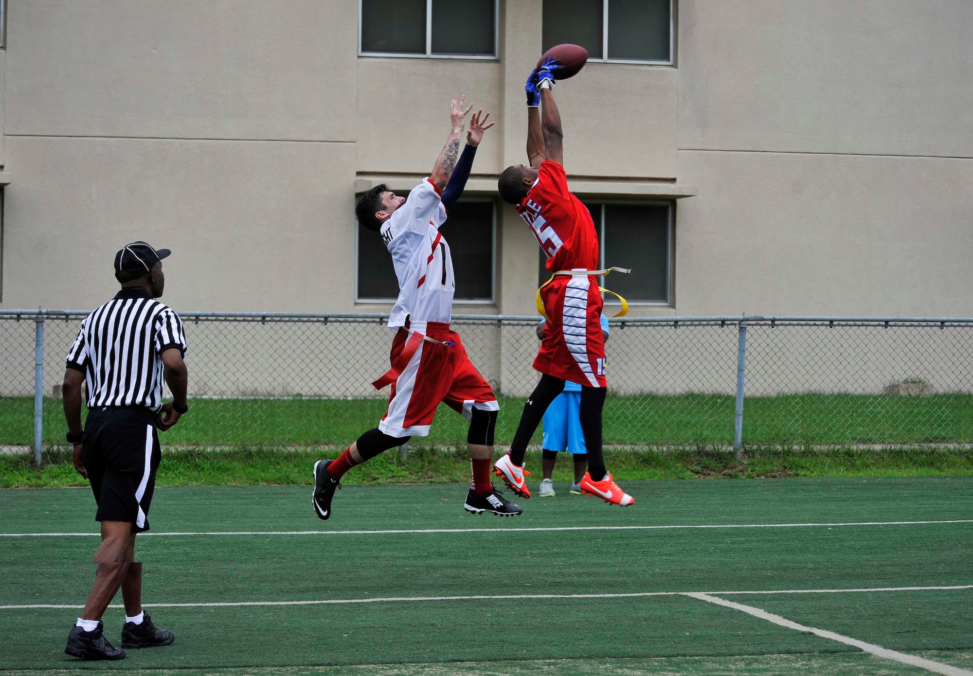 Senior Airman Justin Morgan, 25th Aircraft Maintenance Unit weapons load crew member, deflects a pass to keep Osan’s Team 1 from scoring the extra point at the Osan high school football field, Republic of Korea, August 3, 2014. Osan’s Team 1 won the game 26-7. (U.S. Air Force photo/Senior Airman David Owsianka)