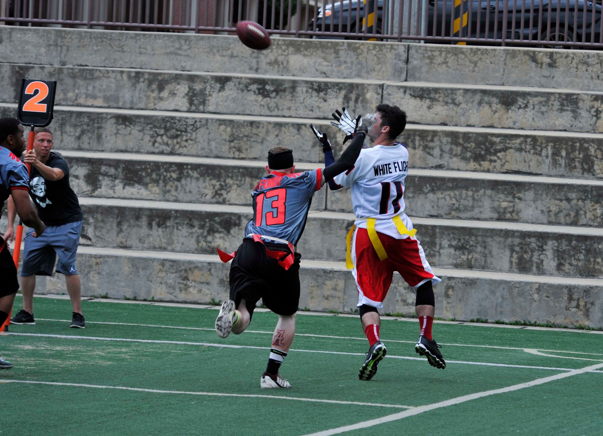 U.S. Army Private First Class Satcha Hooten, 52nd Air Defense Artillery Regiment early morning specialist, prepares to catch a pass during the first half of the semi-finals game against the Kunsan Air Base, Republic of Korea team at the high school football field on Osan AB, ROK, Aug. 3, 2014. Kunsan won the game 19-18. (U.S. Air Force photo/Senior Airman David Owsianka)