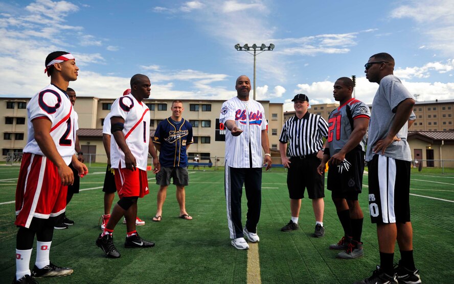 Chief Master Sgt. Joseph Walker, 51st Mission Support Group chief, flips a coin prior to the first game of the King of the Republic of Korea flag football tournament at the high school football field on Osan Air Base, ROK, Aug. 2, 2014. The Mustangs defeated Kunsan AB, ROK, 26-6 during the first game. (U.S. Air Force photo/Senior Airman David Owsianka)