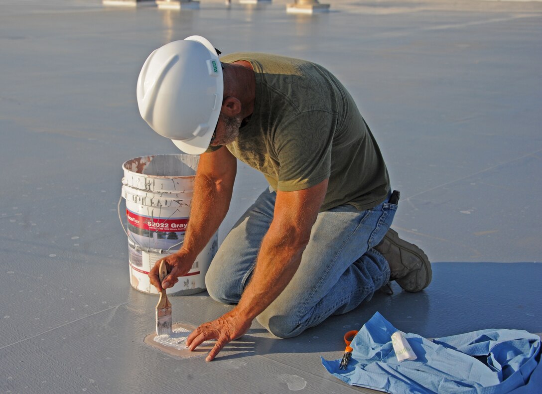 Clark Peterson, 9th Civil Engineer Squadron roof maintenance team carpenter, patches an area on the Base Exchange roof as part of the base roof restoration project July 31, 2014, at Beale Air Force Base, Calif. To date, the roof maintenance team has completed 12 roofs covering more than 90,000 square feet. (U.S. Air Force photo by Airman 1st Class Ramon A. Adelan/ Released)