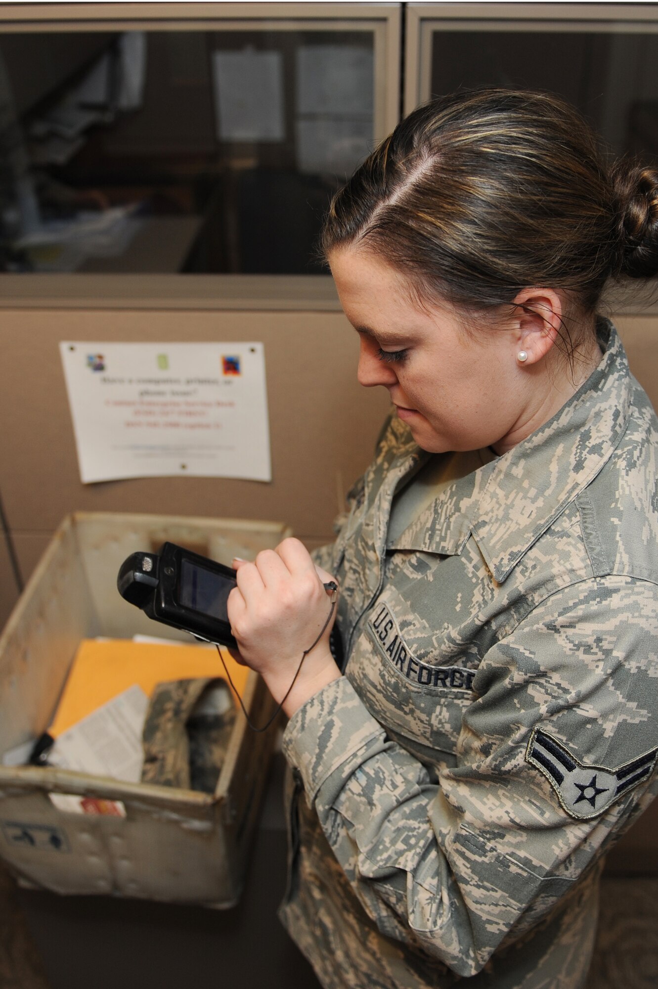 Airman 1st Class Victoria Moore delivers a certified package July 29, 2014 at Scott Air Force Base, Ill.  When a package or letter is certified, Moore is required to get the recipient’s signature when the parcel is dropped off.  This allows the Official Mail Center to track these items.  Moore is an official mail clerk.  (U.S. Air Force photo by Staff Sgt. Maria Bowman)