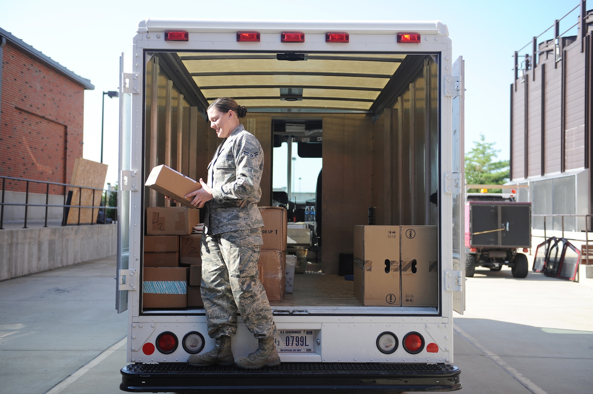 Airman 1st Class Victoria Moore delivers packages to Air Mobility Command July 29, 2014 at Scott Air Force Base, Ill.  The Official Mail Center receives around 1600 pieces of mail every day, which needs to be distributed to 81 organizations around the base.  Moore is an official mail clerk.  (U.S. Air Force photo by Staff Sgt. Maria Bowman)