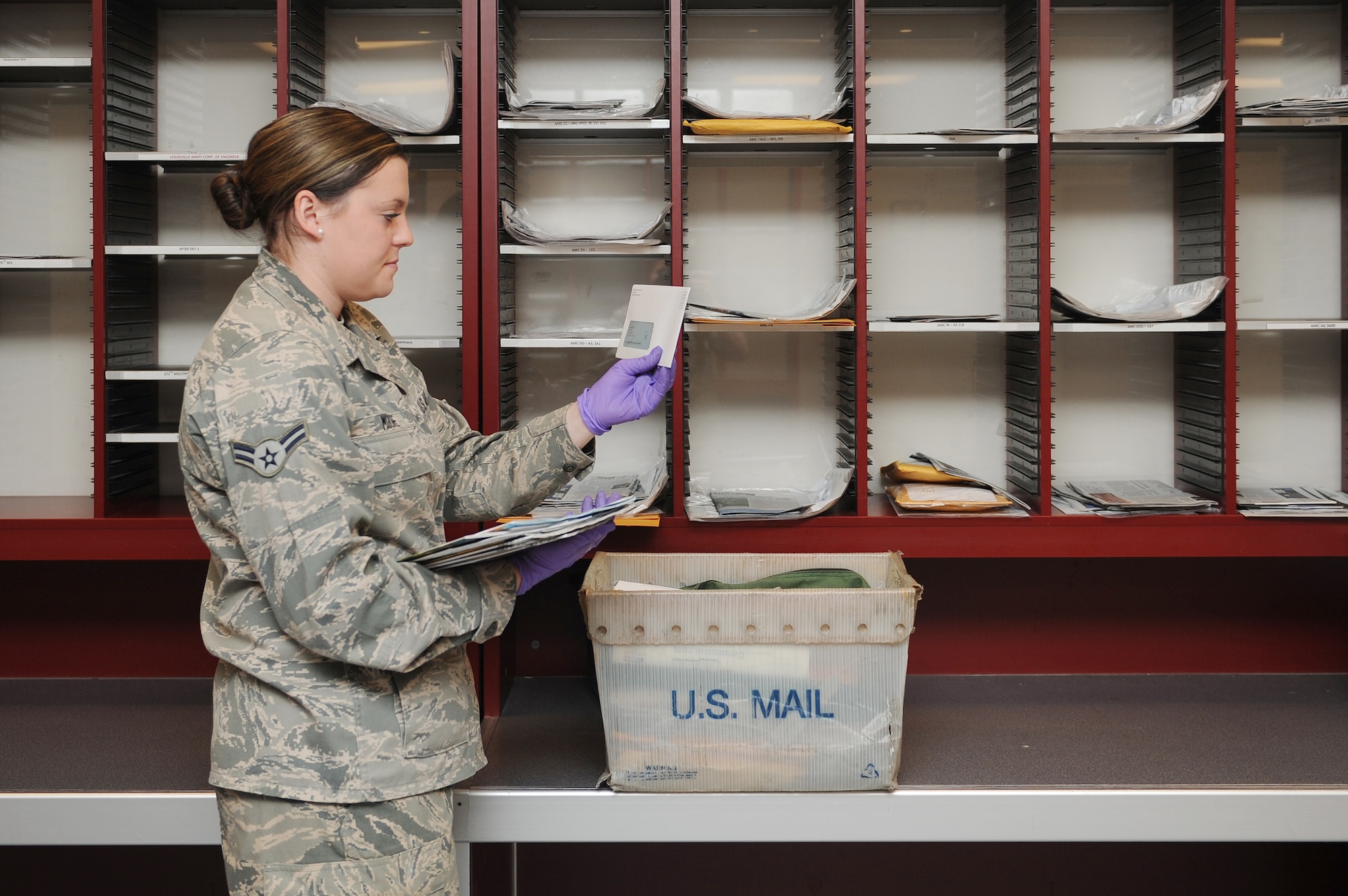 Airman 1st Class Victoria Moore sorts mail July 29, 2014 at Scott Air Force Base, Ill.  Packages and letters are arranged according to the organization they need to be taken to.  After all the parcels have been organized, Moore loads them onto a truck and delivers them across the base.  Moore is an official mail clerk.  (U.S. Air Force photo by Staff Sgt. Maria Bowman)