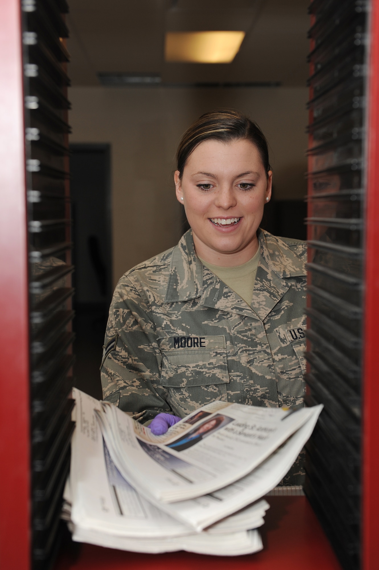 Airman 1st Class Victoria Moore sorts mail July 29, 2014 at Scott Air Force Base, Ill.  Packages and letters are arranged according to the organization they need to be taken to.  After all the parcels have been organized, Moore loads them onto a truck and delivers them across the base.  Moore is an official mail clerk.  (U.S. Air Force photo by Staff Sgt. Maria Bowman)