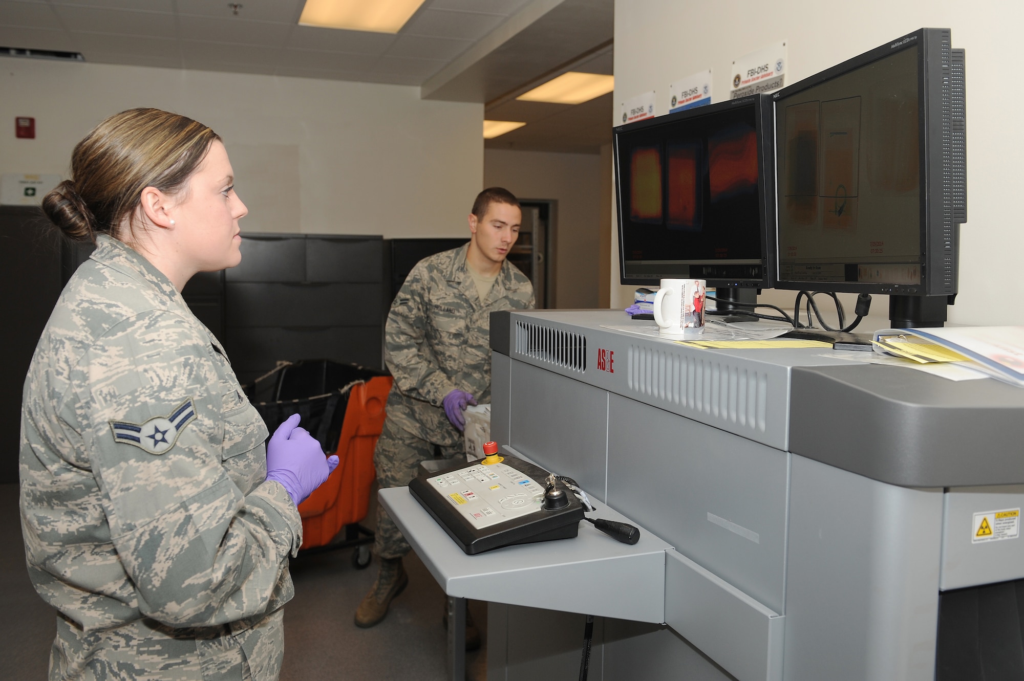 Airman 1st Class Victoria Moore checks mail for illegal items when they pass through the x-ray machine July 29, 2014 at Scott Air Force Base, Ill.  When the Official Mail Center receives packages and letters, they have to be examined for weapons, bombs and chemicals before being delivered to various organizations around the base.  Moore is an official mail clerk.  (U.S. Air Force photo by Staff Sgt. Maria Bowman)