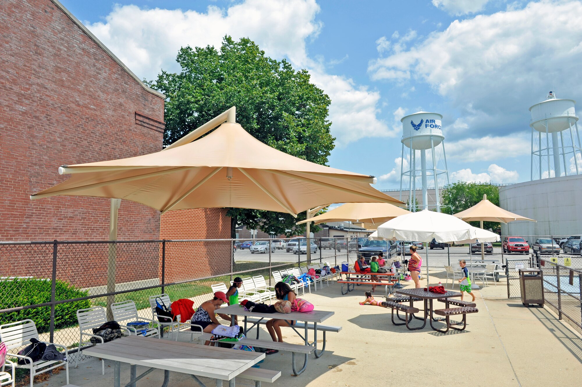 Patrons partake in the shade provided by new umbrellas at the Fitness Center pool at Scott Air Force Base, Ill., July 29, 2014. Outdoor Recreation recently installed six cantilever umbrellas around the pool deck. (U.S. Air Force photo by Airman 1st Class Erica Crossen)