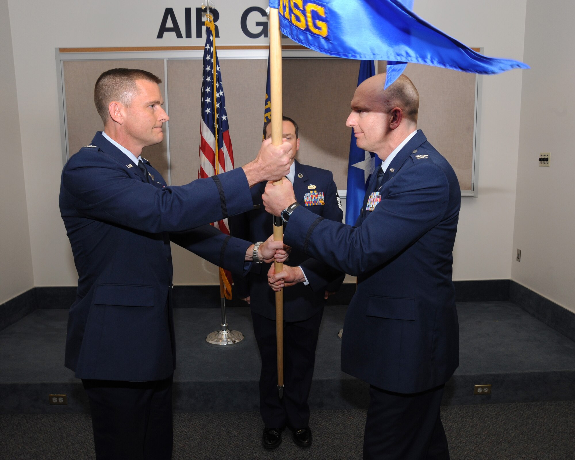 Col. Rick Wedan, 142nd Fighter Wing Commander, left, exchanges the colors with outgoing 142nd MSG Commander Col. Paul Fitzgerald, right, during the Mission Support Group Change of Command Ceremony, Portland Air National Guard Base, Ore., Aug. 3, 2014. (U.S. Air National Guard photo by Tech. Sgt. John Hughel, 142nd Fighter Wing Public Affairs/Released)