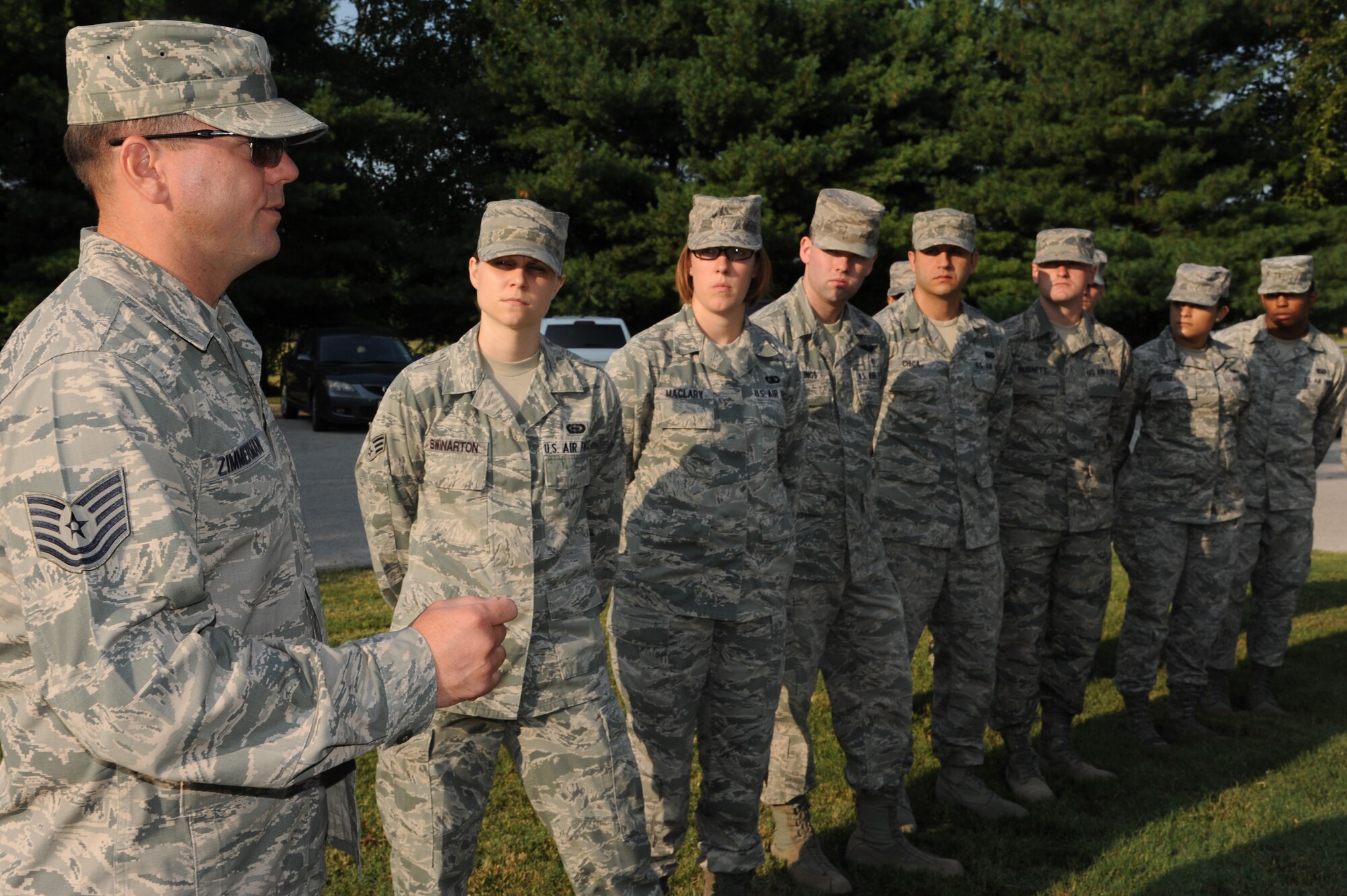 Tech. Sgt. Jeremy Zimmerman, 375th Force Support Squadron's Airman Leadership School instructor, talks to the students about the importance of saluting the flag and showing their respects during a flag detail , July 28, 2014 at Scott Air Force Base, Ill. Every morning ALS students rotate amongst each other to perform a flag detail. Two airman unfold and raise the flag, one student calls the commands while two students are inside giving signals to each other to play the National Anthem. (U.S. Air Force photo/ Senior Airman Tristin English)
