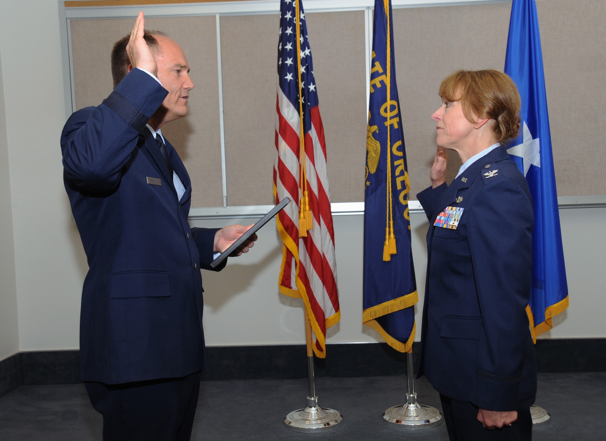 Brig. Gen. Michael Stencel, Commander of the Oregon Air National Guard, left, reaffirms the officer’s oath to newly promoted Col. Donna Prigmore during her promotion ceremony held at the Portland Air National Guard Base, Ore., Aug. 3, 2014. (U.S. Air National Guard photo by Tech. Sgt. John Hughel, 142nd Fighter Wing Public Affairs/Released)