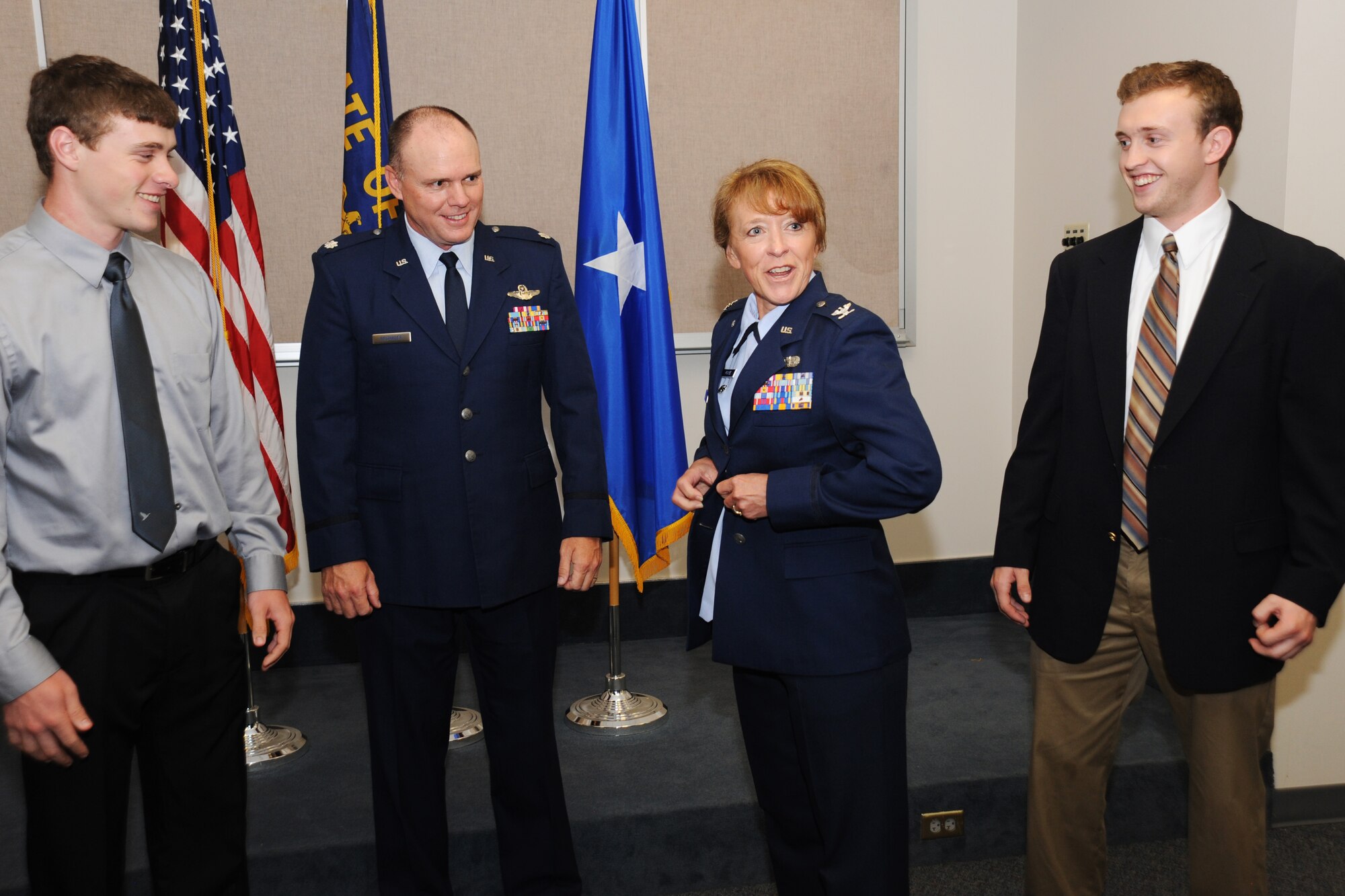 Newly promoted Colonel Donna Prigmore don a jacket bearing the colonel insignia with the assistance of her husband Lt. Col. John Prigmore, during her promotion ceremony held at the Portland Air National Guard Base, Ore., Aug. 3, 2014. (U.S. Air National Guard photo by Tech. Sgt. John Hughel, 142nd Fighter Wing Public Affairs/Released)