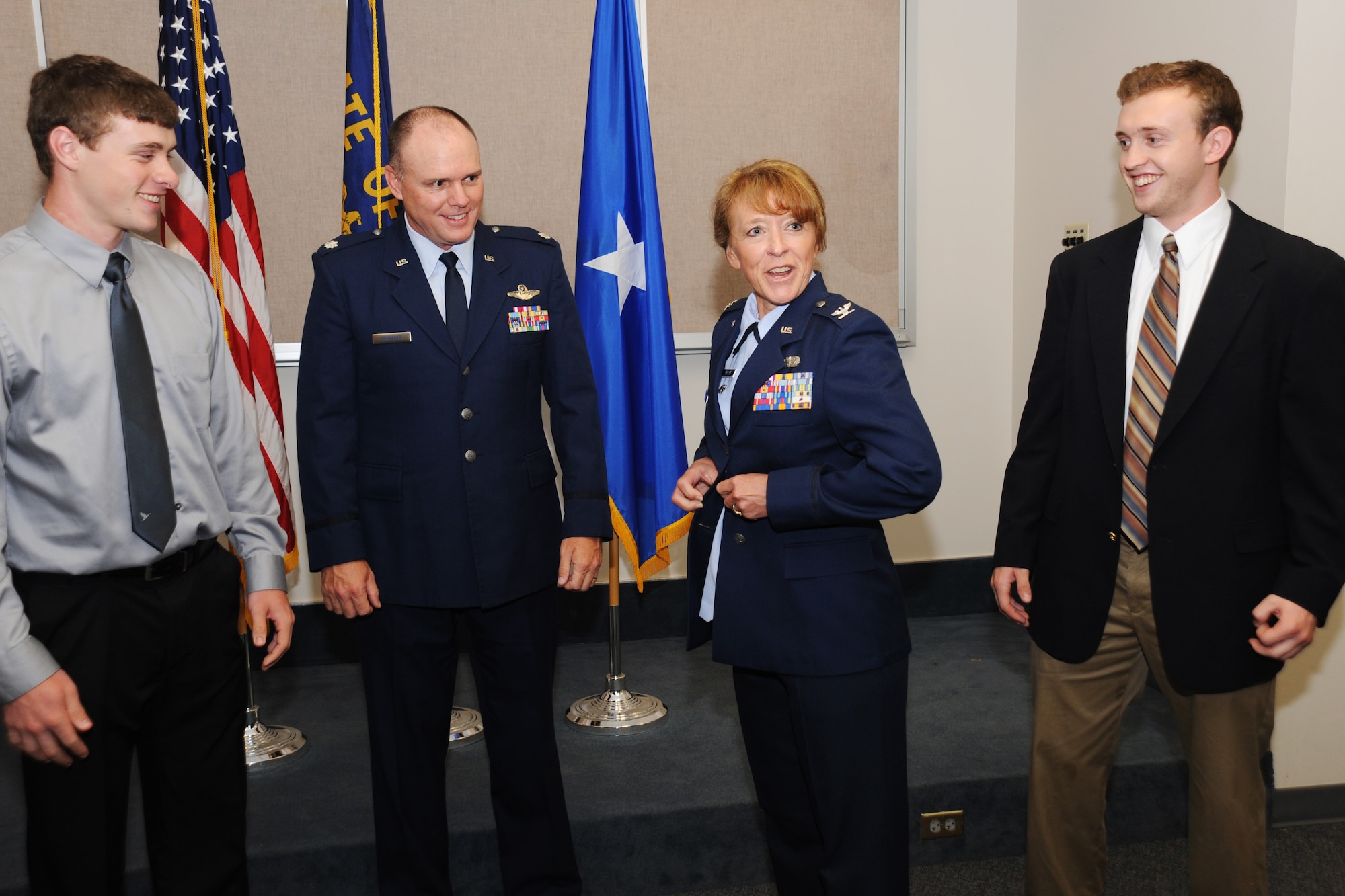 Newly promoted Colonel Donna Prigmore don a jacket bearing the colonel insignia with the assistance of her husband Lt. Col. John Prigmore, during her promotion ceremony held at the Portland Air National Guard Base, Ore., Aug. 3, 2014. (U.S. Air National Guard photo by Tech. Sgt. John Hughel, 142nd Fighter Wing Public Affairs/Released)