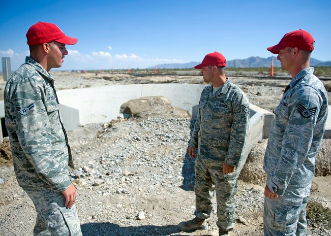 (From left to right) Airman 1st Class Christopher Fitzgerald, Tech. Sgt. Adam Dixon and Staff Sgt. James Maxwell, all members of the 820th RED HORSE, Nellis Air Force Base, Nev., check out the spot where a car belonging to an elderly couple they saved from a flash flood ended up on U.S. Route 95 north of Las Vegas, Nev., Aug. 5, 2014. During the rescue, Dixon and Maxwell held the car door open so Fitzgerald could reach in, grab and carry the woman to higher ground. (U.S. Air Force photo by Staff Sgt. Siuta B. Ika)