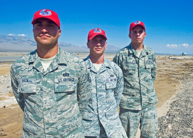(From left to right) Tech Sgt. Adam Dixon, Staff Sgt. James Maxwell and Airman 1st Class Christopher Fitzgerald, all members of the 820th RED HORSE, pose for a photo on Aug. 5, 2014, in front of the spot where the three Airmen, assisted by three members of the 799th Air Base Squadron, saved an elderly couple who were trapped in their car during a flash flood Aug. 4, on U.S. Route 95 north of Las Vegas, Nev. The Airmen were on their way home from their work sites at Creech Air Force Base when they saw the couple’s car stuck in the median, and took swift action before the flood carried the car away. (U.S. Air Force photo by Staff Sgt. Siuta B. Ika)