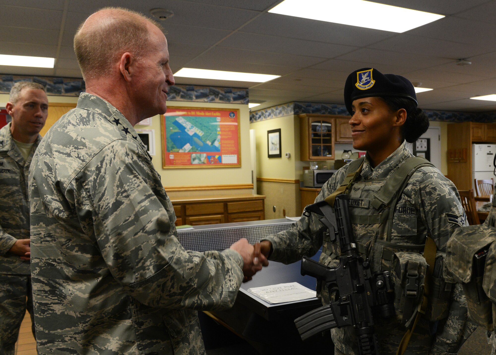 Lt. Gen. Stephen Wilson, Air Force Global Strike Command commander, shakes hands with Airman 1st Class Ginelle Metiviet, 341st Missile Security Forces Squadron member, after listening to her explain her job duties at India 1 missile alert facility Aug. 5. Wilson discussed the impact of Force Improvement Program initiatives during his tour of the MAF, to include wireless internet, updated furniture and kitchen equipment. (U.S. Air Force photo/Senior Airman Katrina Heikkinen)