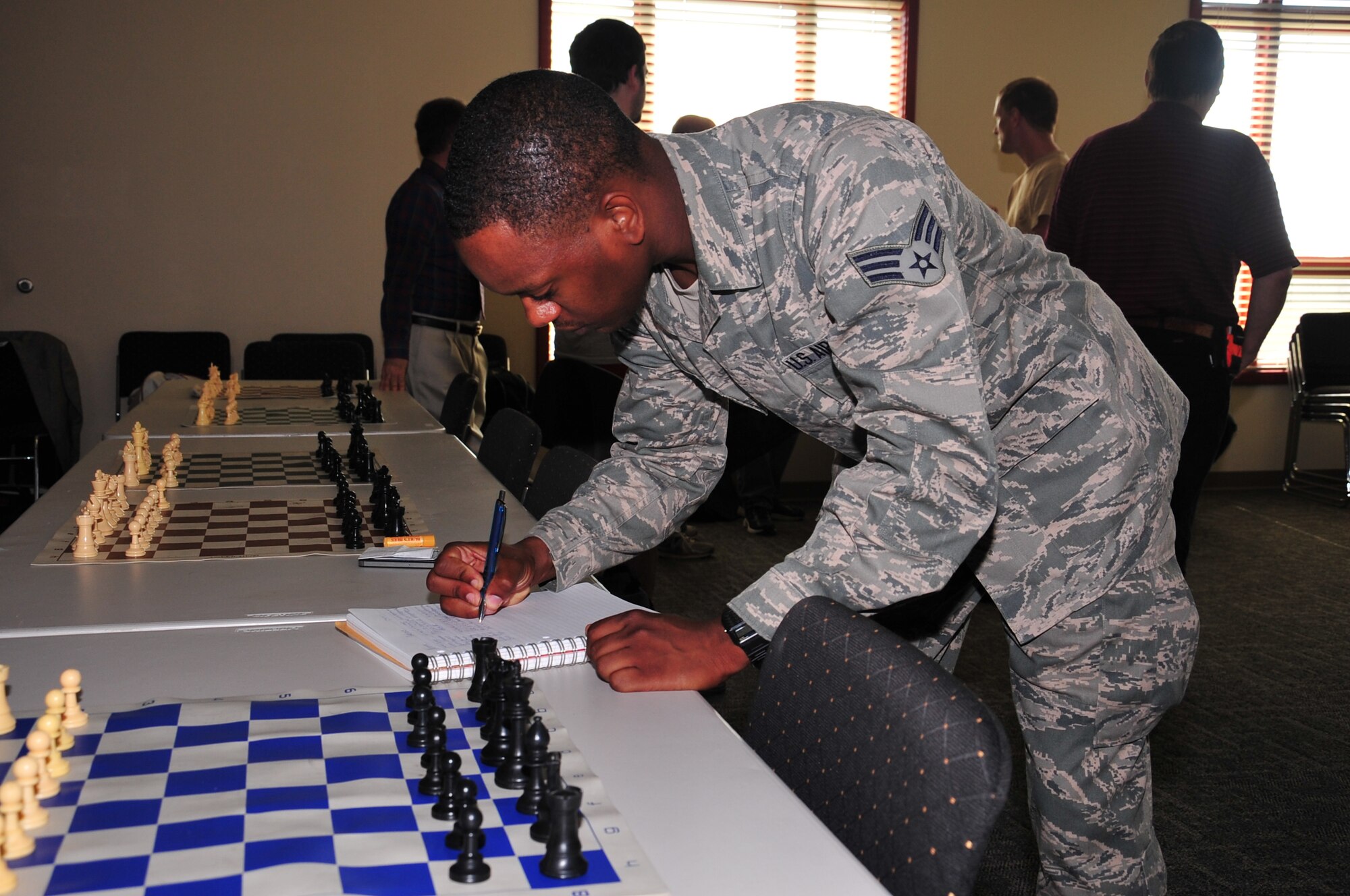 Senior Airman Brian Pope, 55th Communications Squadron, registers for the first annual Chess Fair held at The Point in Rising View Housing located near Offutt Air Force Base, Nebraska. Pope organized the fair as a way to give back to the game that helped him cope with serious injuries stemming from a car accident. (U.S. Air Force photo by D.P. Heard/Released) 
