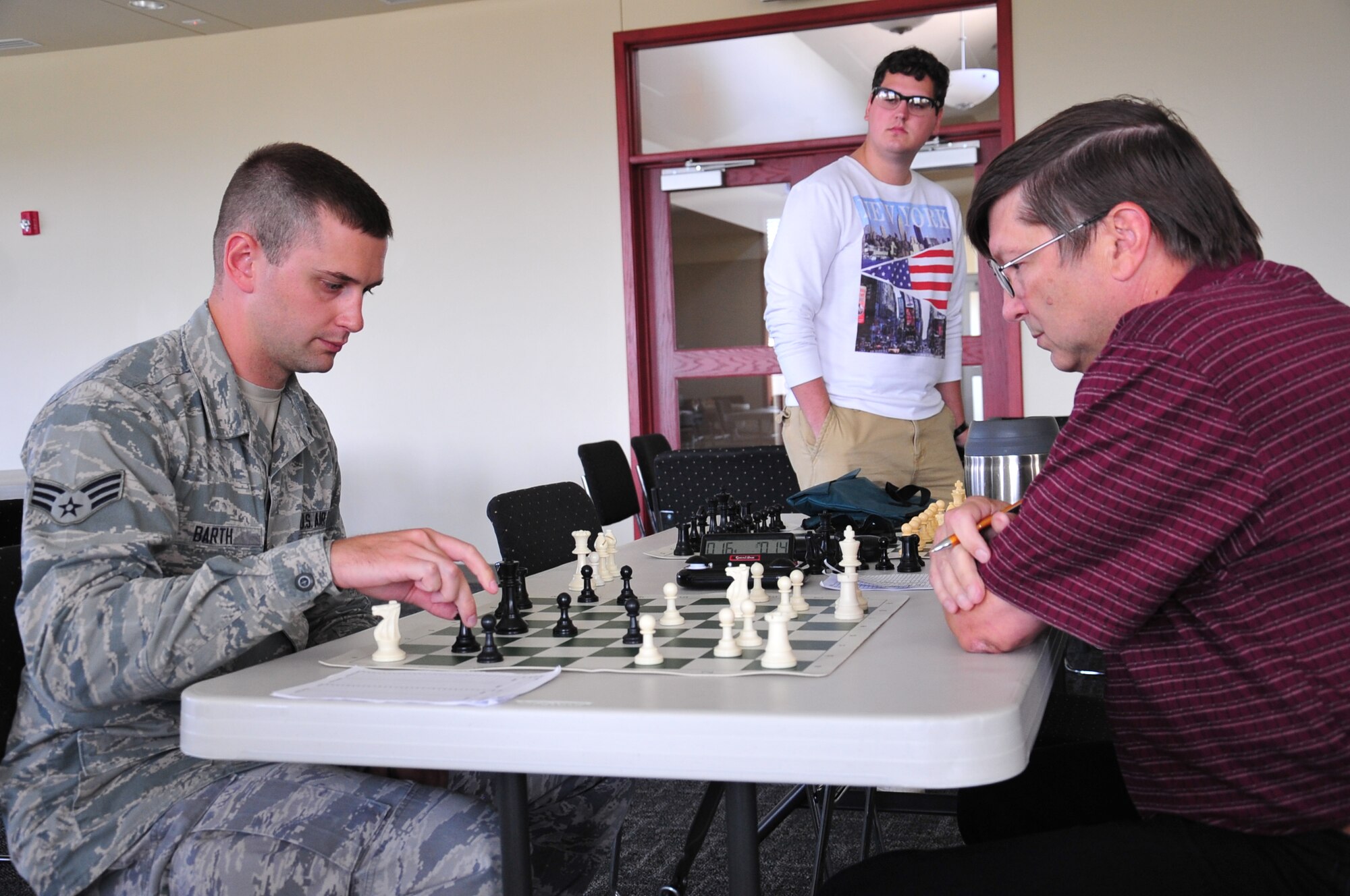 Senior Airman Caleb Barth, 55th Strategic Communications Squadron, squares off against Raymond Brooks, 55th CS, at the first Chess Fair that was held at The Point in Rising View housing located near Offutt Air Force Base, Nebraska. Proceeds from the event went to the Husker Salute Organization.
(U.S. Air Force photo by D.P. Heard/Released)
