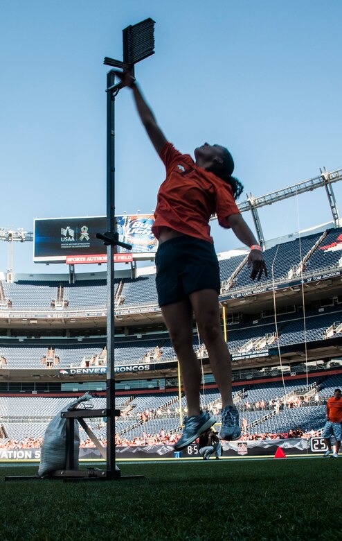 Laura England, 50th Operations Support Squadorn, competes in the vertical leap as part of the USAA-Broncos Military Combine Aug. 2, 2014, at Sports Authority Field in Denver. Ten Schriever Air Force Base Airmen competed in the military combine against other Front Range service members from Peterson Air Force Base, U.S. Air Force Academy and Fort Carson. (U.S. Air Force photo/Staff Sgt. Julius Delos Reyes)