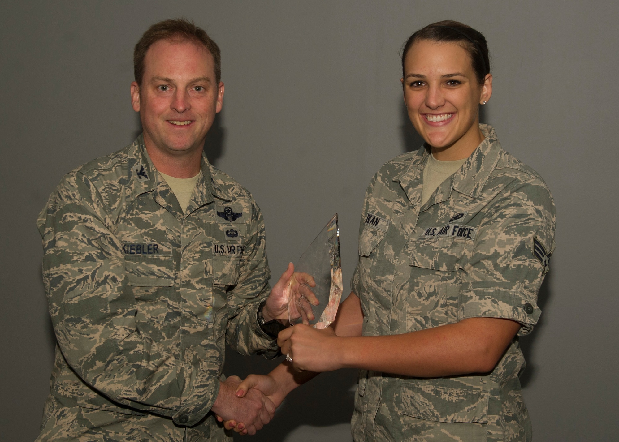 Colonel Robert Kiebler, 49th Wing commander, presents Senior Airman Erika Bean, 49th Operations Support Squadron, an award naming her as the Airfield Management Journeyman of the Year at Holloman Air Force Base, N.M., Aug. 6. Bean was also coined by the Air Combat Command Inspector General for her efforts during the Airfield Operations Compliance Inspection. She was also recognized for organizing 12 distinguished visitors air craft taxi routing and parking, with zero delay. (U.S. Air Force photo by Airman 1st Class Chase Cannon/ Released) 
