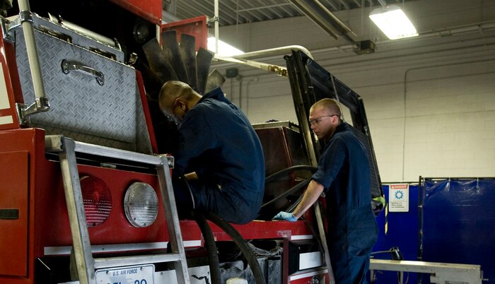 Staff Sgt. Shawn Bailey (right) and Senior Airman Newjay Manguya, 99th Logistics Readiness Squadron vehicle mechanics, assist with maintenance on a fire truck radiator at Nellis Air Force Base, Nev. Aug. 5, 2014. The shop has four teams assigned to a specific mechanical job such as team two that specifically work on fire engines.  (U.S. Air Force photo by Airman 1st Class Rachel Loftis)