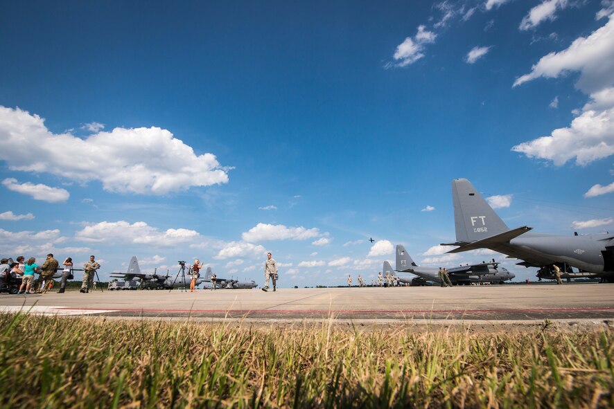 Airmen from the 71st Rescue Squadron and 723d Aircraft Maintenance Squadron, as well as their families, exit the flightline following a deployment return at Moody Air Force Base, Ga., Aug 5, 2014. The 71st RQS completed the final active-duty HC-130P Combat King deployment and, by September 2015, will finalize the transition to the newer HC-130J Combat King II. (U.S. Air Force photo by Airman 1st Class Ryan Callaghan/Released)