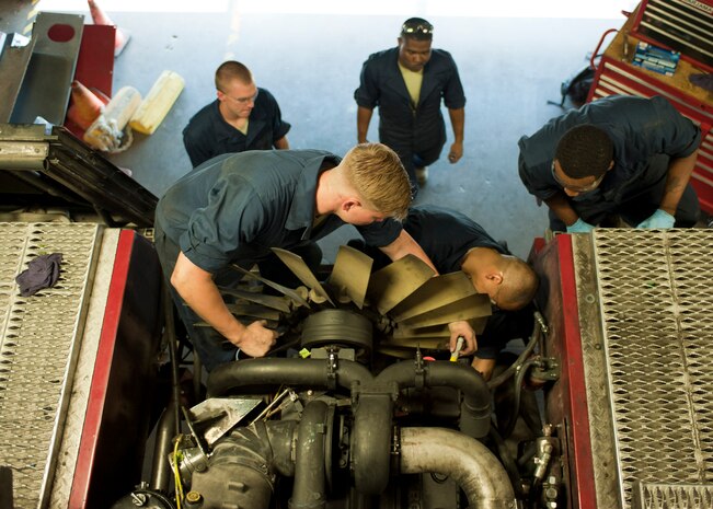 U.S. Air Force fire truck mechanics from the 99th Logistics Readiness Squadron prepare to place a radiator into a fire engine at Nellis Air Force Base Nev. Aug. 5, 2014. The 99th LRS Vehicle Management Flight is comprised of 91 military personnel and 27 civilian workers. (U.S. Air Force photo by Senior Airman Timothy Young)