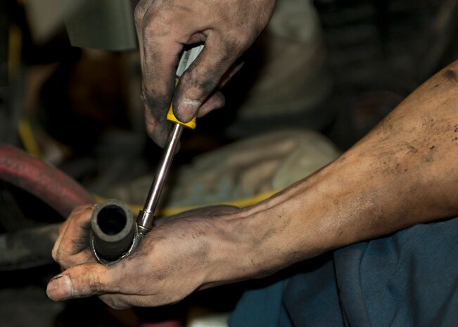 Senior Airman Newjay Mangaya, 99th Logistics Readiness Squadron fire truck mechanic, prepares a radiator hose to be attached at Nellis Air Force Base Nev. Aug. 5, 2014. In January 2006, the 99th LRS Vehicle Management Flight moved into a brand new 80,000 square foot building. (U.S. Air Force photo by Senior Airman Timothy Young)