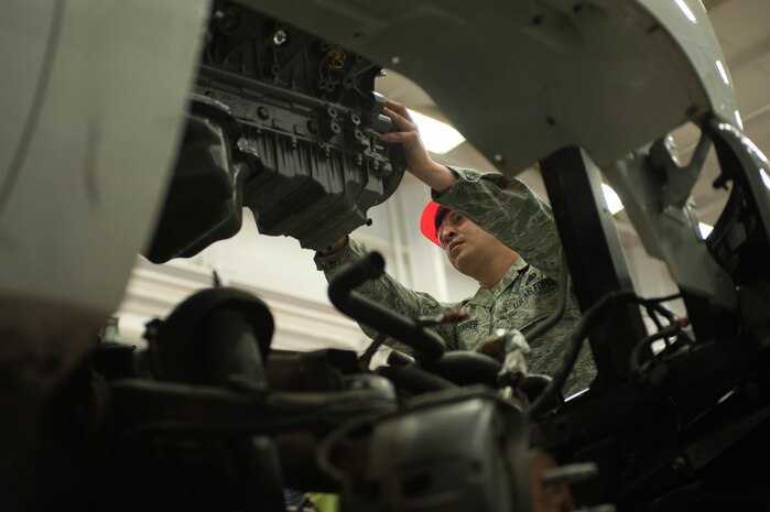 Staff Sgt. Larry Torres, 99th Logistics Readiness Squadron vehicle mechanic, pushes a suspended engine into position at Nellis Air Force Base Nev. Aug. 5, 2014. The 99th LRS Vehicle Management Flight crew manages the largest fleet in Air Combat Command with over 1,800 vehicles. (U.S. Air Force photo by Senior Airman Timothy Young)