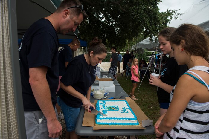 Rachel Gentry, U.S.C.G. Sector Charleston Ombudsman, cuts a birthday cake during the Coast Guard birthday celebration Aug. 4, 2014, at U.S.C.G. Sector Charleston, S.C. Members of the Coast Guard and their families celebrated the 224th birthday of the Coast Guard, the United States’ oldest continuous sea-going service..  (U.S. Air Force photo/Senior Airman George Goslin)