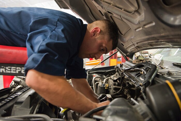 Senior Airman Carlos Limon, 99th Logistics Readiness Squadron vehicle mechanic, makes repairs on a security forces vehicle at Nellis Air Force Base, Nev. Aug. 5, 2014. The 99th LRS is responsible for repairing and maintaining all government owned vehicles on base. (U.S. Air Force photo by Airman 1st Class Thomas Spangler)