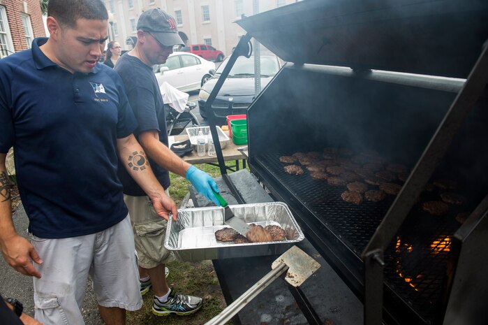 Volunteers cook burgers for the Coast Guard birthday celebration Aug. 4, 2014, at U.S.C.G. Sector Charleston, S.C. The celebration included a cook-out, games and raffle prizes. (U.S. Air Force photo/Senior Airman George Goslin)