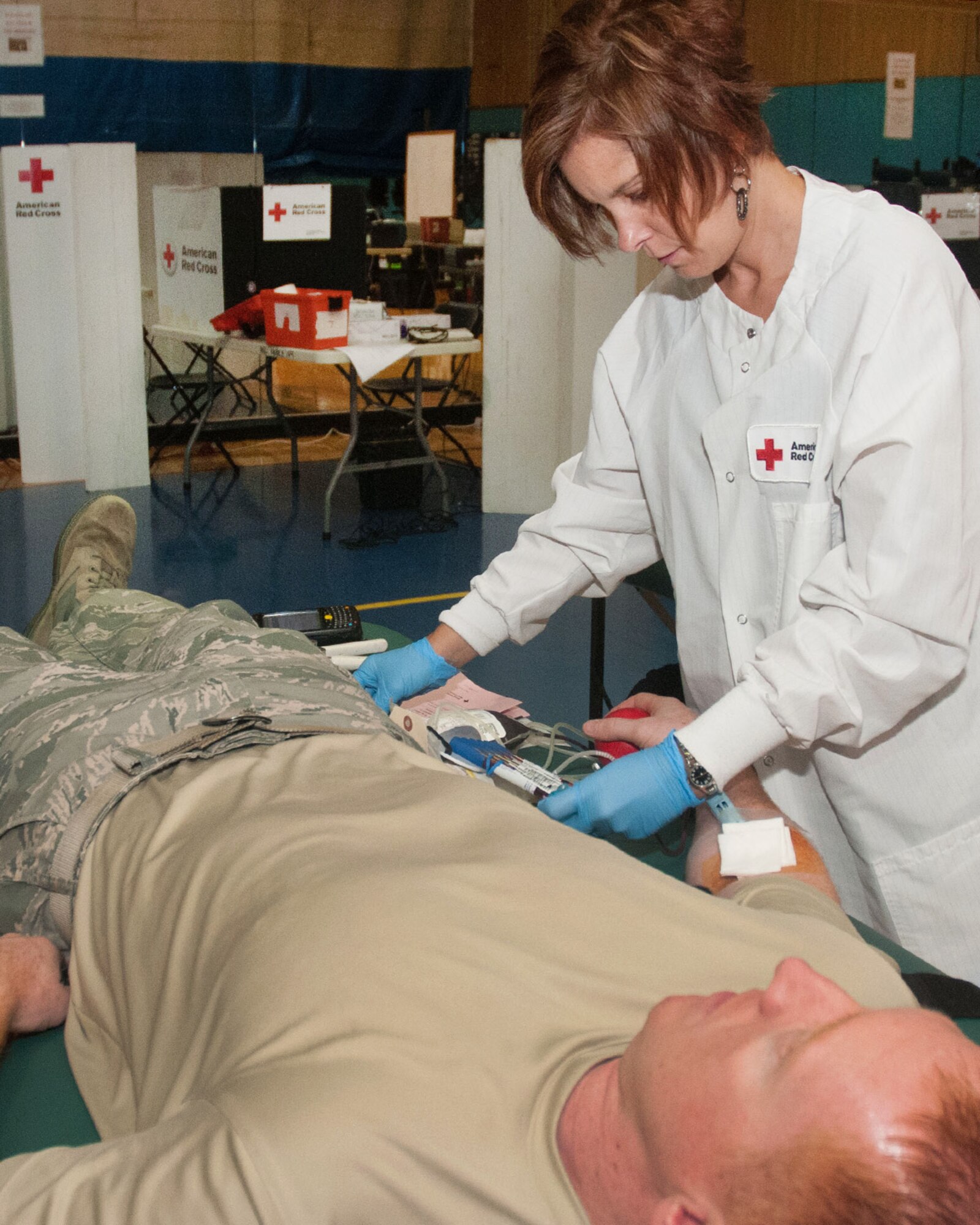 HANSCOM AIR FORCE BASE, Mass. – Tina Bass (right), a Red Cross staff member, draws blood from Senior Master Sgt. Wesley Keville at the Hanscom Fitness and Sports Center during a Red Cross Blood Drive Aug. 8. Hanscom collects more than 100 units during a usual two-day blood drive on base. For more information on donating blood through the Red Cross, visit redcross.org/donate/give. (U.S. Air Force photo by Mark Herlihy)