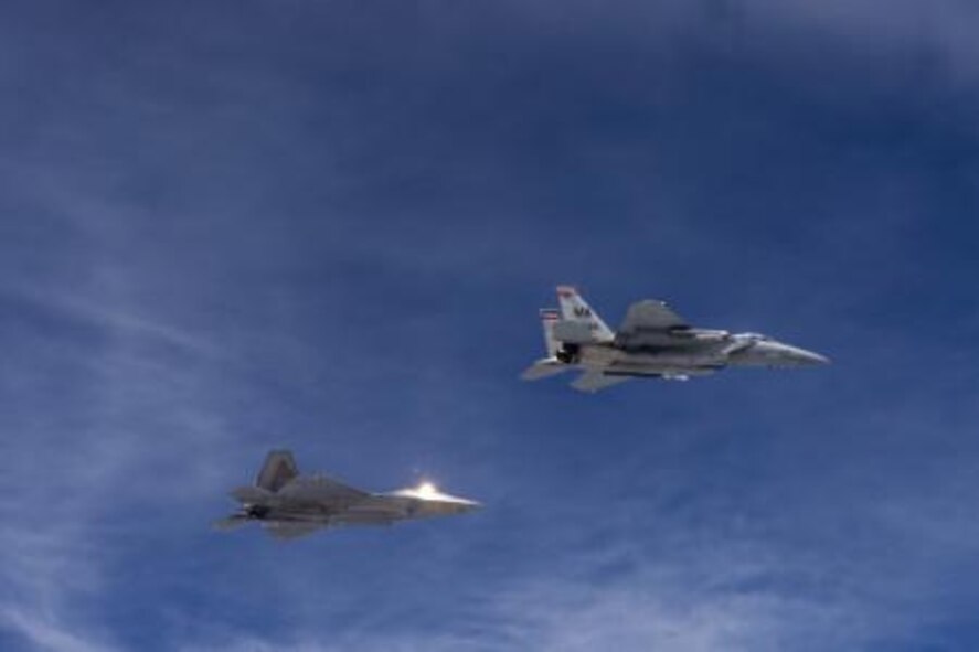 A U.S. Air Force F-22 Raptor from the 154th Wing, Joint Base Pearl Harbor-Hickam, Hawaii, and U.S. Air Force F-15 Eagle from the 131st Fighter Squadron, 104th Fighter Wing, Barnes Air National Guard Base, Mass., fly over Penang, Malaysia, during Cope Taufan 14, June 16, 2014. Cope Taufan is a biennial large force employment exercise taking place June 9 to 20 designed to improve U.S. and Malaysian combined readiness. (U.S. Air Force photo by Tech. Sgt. Jason Robertson/Released) 