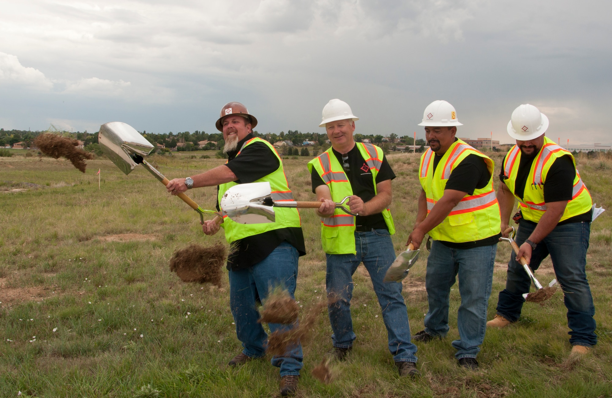 From left, Tom McGetrick, Michael O’Sullivan, Leonard Torres and Mutaz Said, all contractors working on the new accessible community park and new accessible playground projects, break ground at their construction site during a ceremony Aug. 5, 2014, at the chapel on Buckley Air Force Base, Colo. The projects, which are estimated to cost approximately $500,000, are scheduled to be complete in September. (U.S. Air Force photo by Tech. Sgt. Kali L. Gradishar/Released)