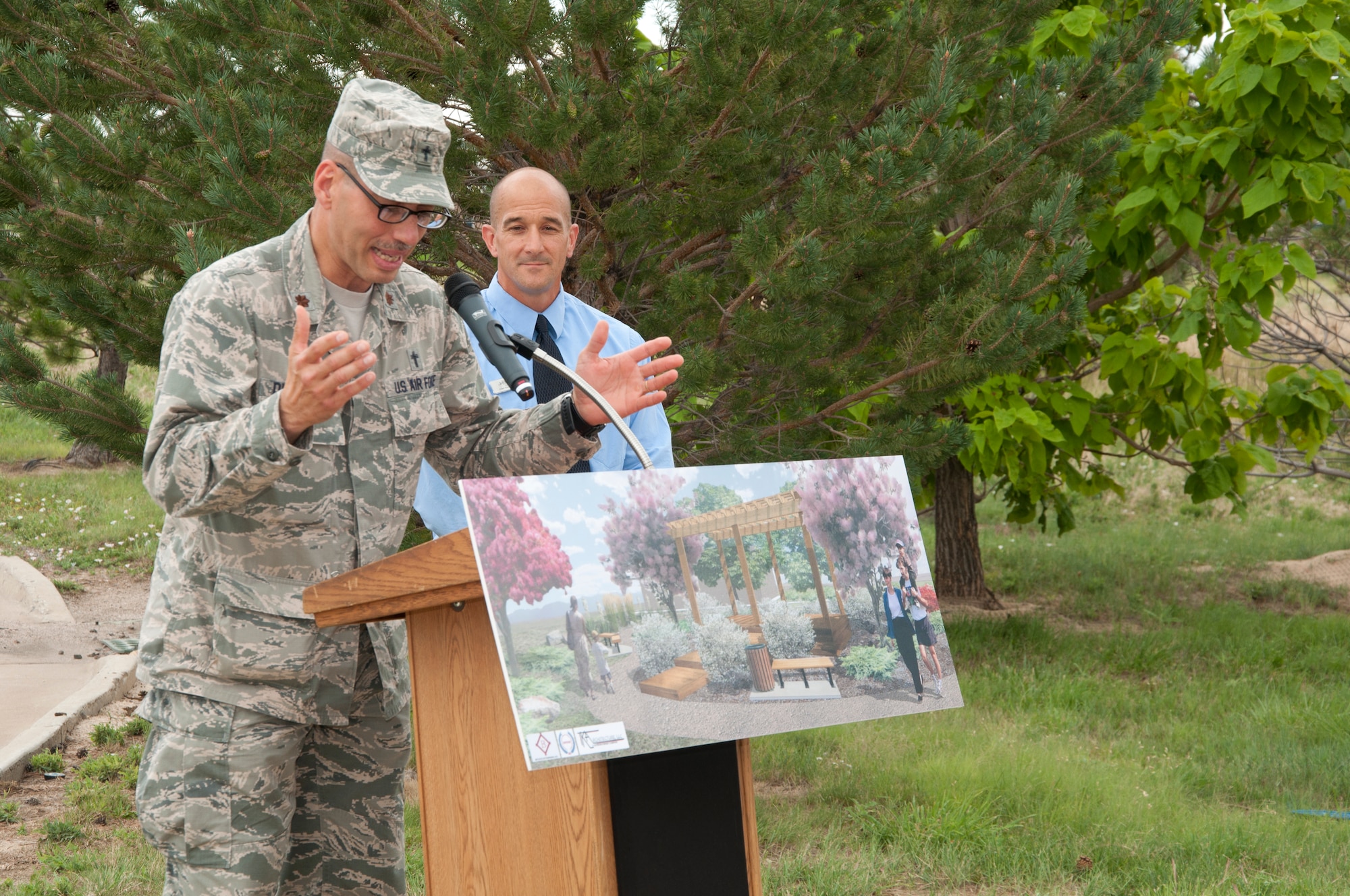 Chaplain (Maj.) David Del Prado, 460th Space Wing chaplain, left, gives the invocation during a ground breaking ceremony for a new accessible community park and an accessible playground while Tom Cox, 460th Force Support Squadron youth programs chief, looks on Aug. 5, 2014, at the chapel on Buckley Air Force Base, Colo. The community park will be located near the chapel, and the accessible playground will be a renovation of a current playground area. The projects, which are estimated to cost approximately $500,000, are scheduled to be complete in September. (U.S. Air Force photo by Tech. Sgt. Kali L. Gradishar/Released)
