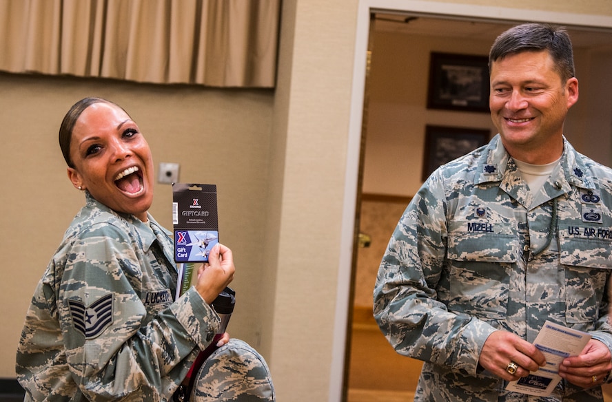 U.S. Air Force Tech. Sgt. Michelle Luckett, 23d Wing NCO in charge of equal opportunity complaints, poses for a photo beside Lt. Col Jonathan Mizell, 23d Force Support Squadron commander, during the annual Education Fair at Moody Air Force Base, Ga., Aug. 6, 2014. Luckett won the first door prize of the day, a gift card to the Base Exchange. (U.S. Air Force photo by Airman  1st Class Ceaira Tinsley/Released)