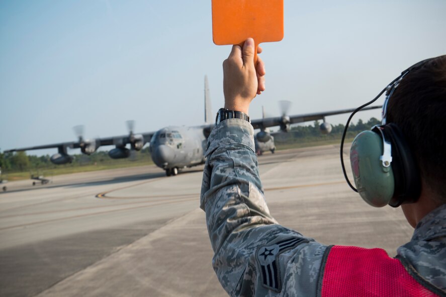 U.S. Air Force Senior Airman Chad Mitchell, 723d Aircraft Maintenance Squadron assistant dedicated crew chief, marshals HC-130P Combat King, tail number 64-4863, from the C-130 ramp at Moody Air Force Base, Ga., Aug. 6, 2014. Mitchell has been the aircraft’s assistant dedicated crew chief since 2012. (U.S. Air Force photo by Staff Sgt. Jamal D. Sutter/Released)