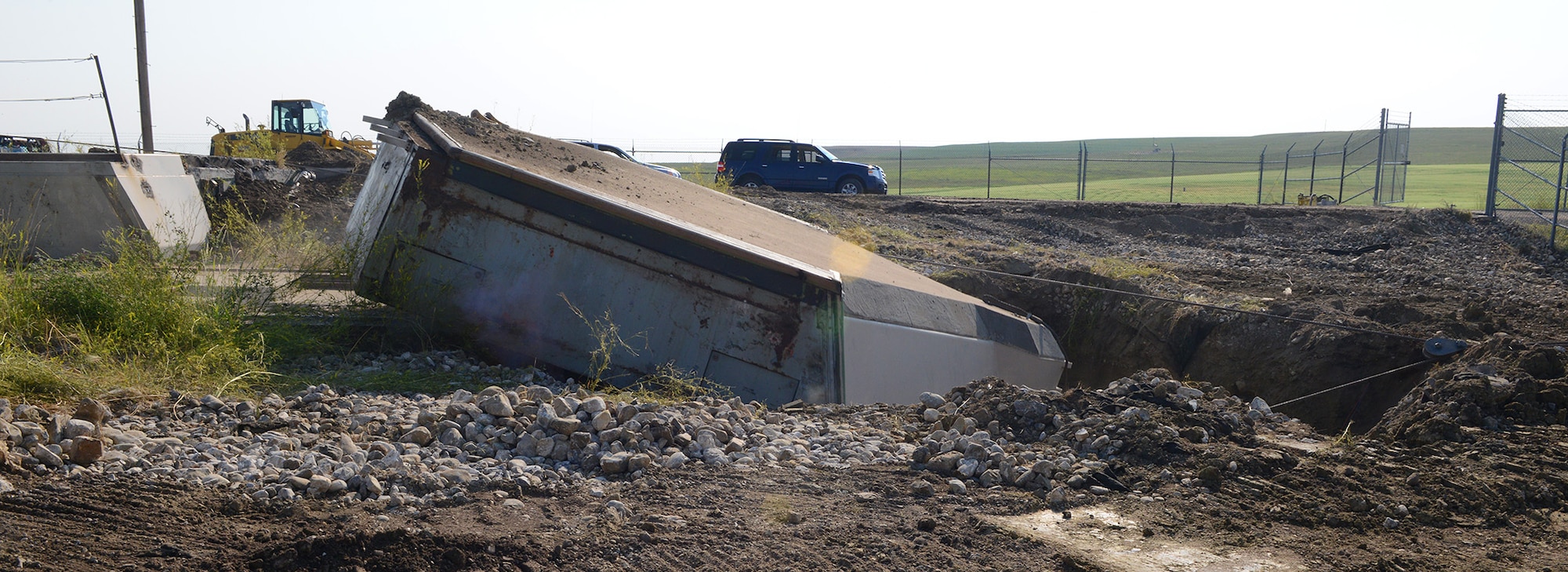 The 110-ton launcher-closure door at Launch Facility T-49 is pulled off its rails into a hole August 5, 2014. The site is the last of 50 Minuteman III missile launch silos once operated by the 564th Missile Squadron that are being eliminated from Malmstrom Air Force Base, Mont., in compliance with the New Strategic Arms Reduction Treaty. (Air Force photo/Senior Airman Katrina Heikkinen)