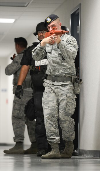 Airman 1st Class Brandon Trapp, 436th Security Forces Squadron, leads a military and civilian clearing team through building 520 during an active shooter scenario Aug. 1, 2014, at Dover Air Force Base, Del. Trapp is a law-enforcement specialist and the personnel immediately behind him are tactical medics from the Kent County SWAT Medic Team. (U.S. Air Force photo/Greg L. Davis)