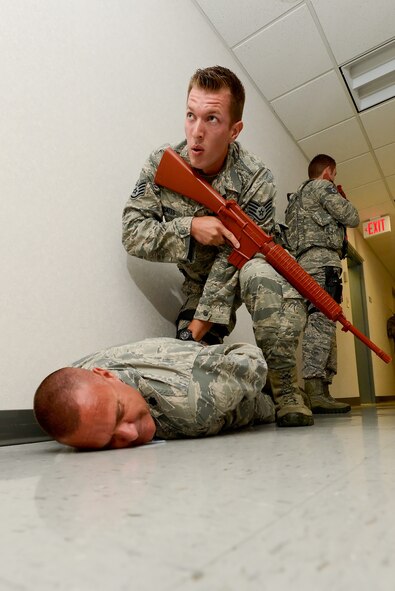 Staff Sgt. Brian Lecates, 436th Security Forces Squadron, secures a suspect after he was neutralized by a breaching-team during a Major Accident Response Exercise with active shooter scenario Aug. 1, 2014, at Dover Air Force Base, Del. The exercise took place inside Building 520 and involved military police, medical and other emergency services along with their civilian counterparts from the local area. (U.S. Air Force photo/Greg L. Davis)